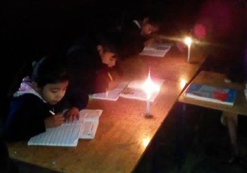 Estudiantes de la Escuela René Alberto Robles de León de San Pedro Carchá se alumbran con candelas para recibir clases. (Foto Prensa Libre: Eduardo Sam).