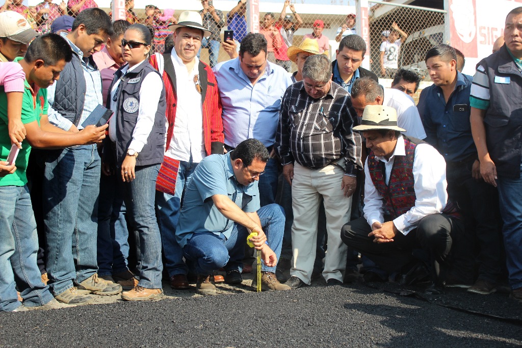 El presidente Jimmy Morales mide el grosor de la capa asfáltica que se coloca en la carretera entre Joyabaj, Quiché, y San Martín Jilotepeque, Chimaltenango. (Foto Prensa Libre: Óscar Figueroa)