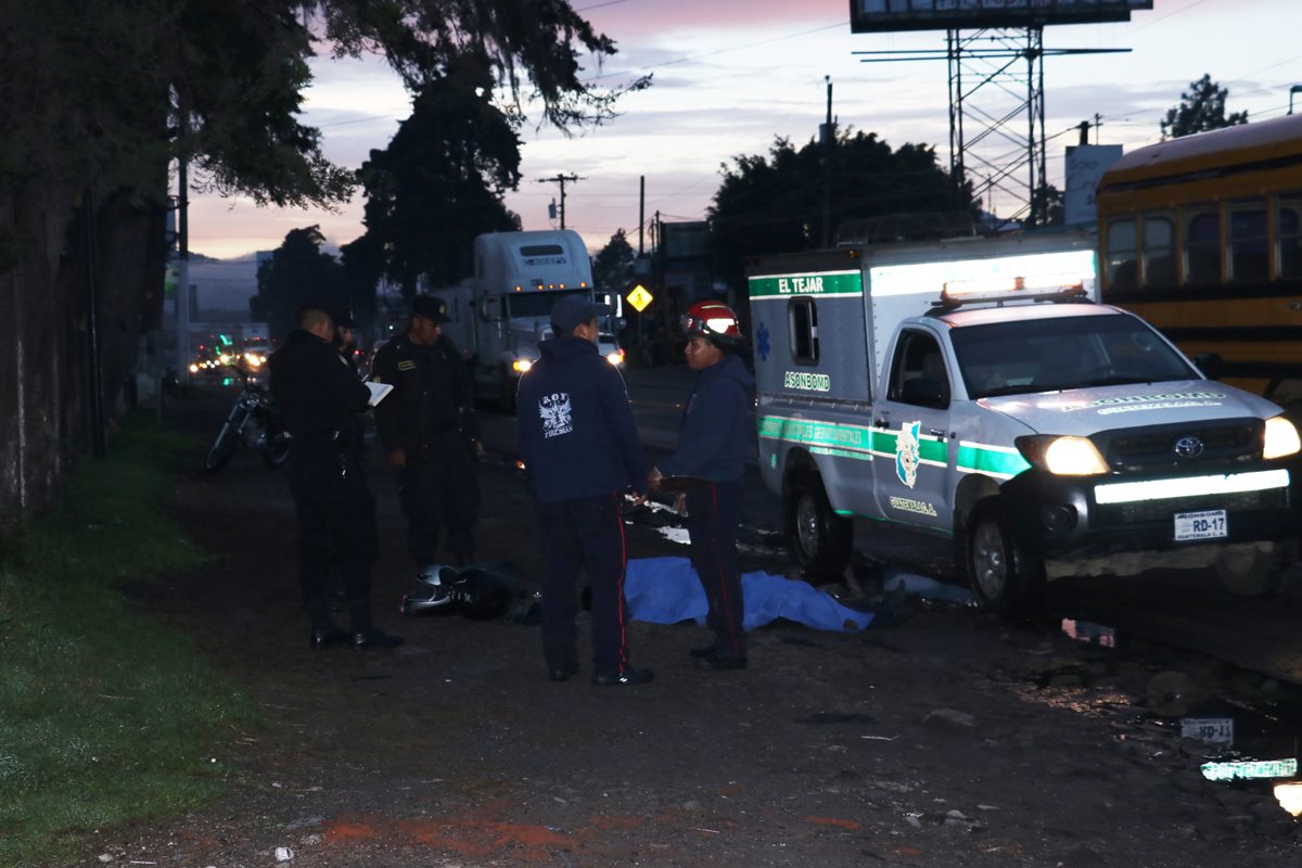 Los socorristas observan el cuerpo del piloto de la motocicleta, el cual quedó a un costado de la ruta Interamericana, en Chimaltenango. (Foto Prensa Libre: Víctor Chamalé)