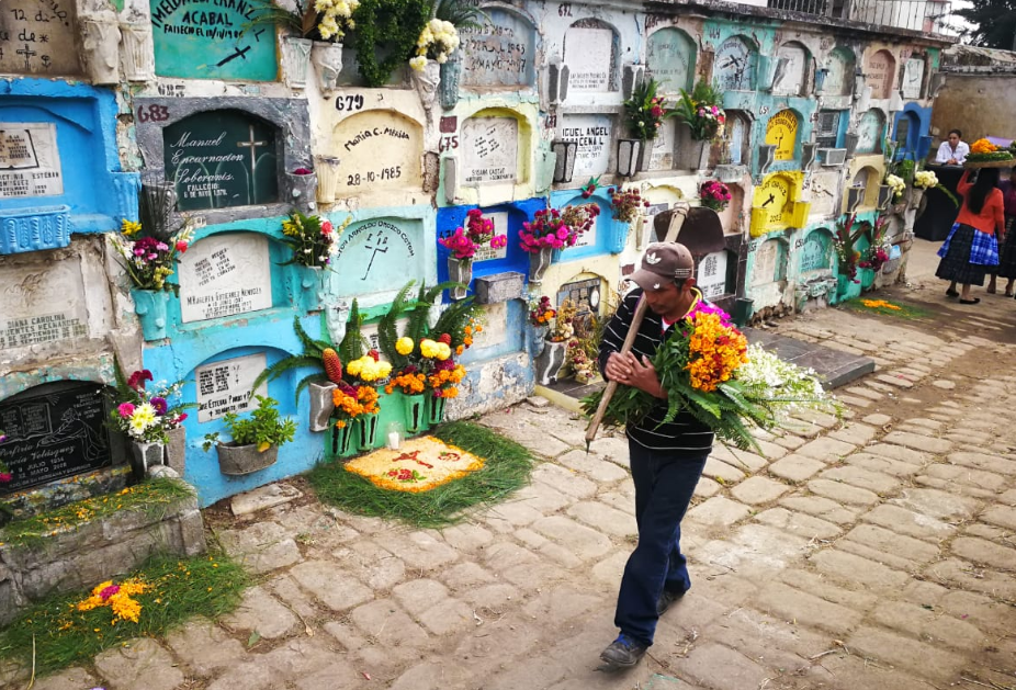 Visitante se dirige a adornar tumba en el cementerio general de Quetzaltenango. (Foto Prensa Libre: Mynor Toc).