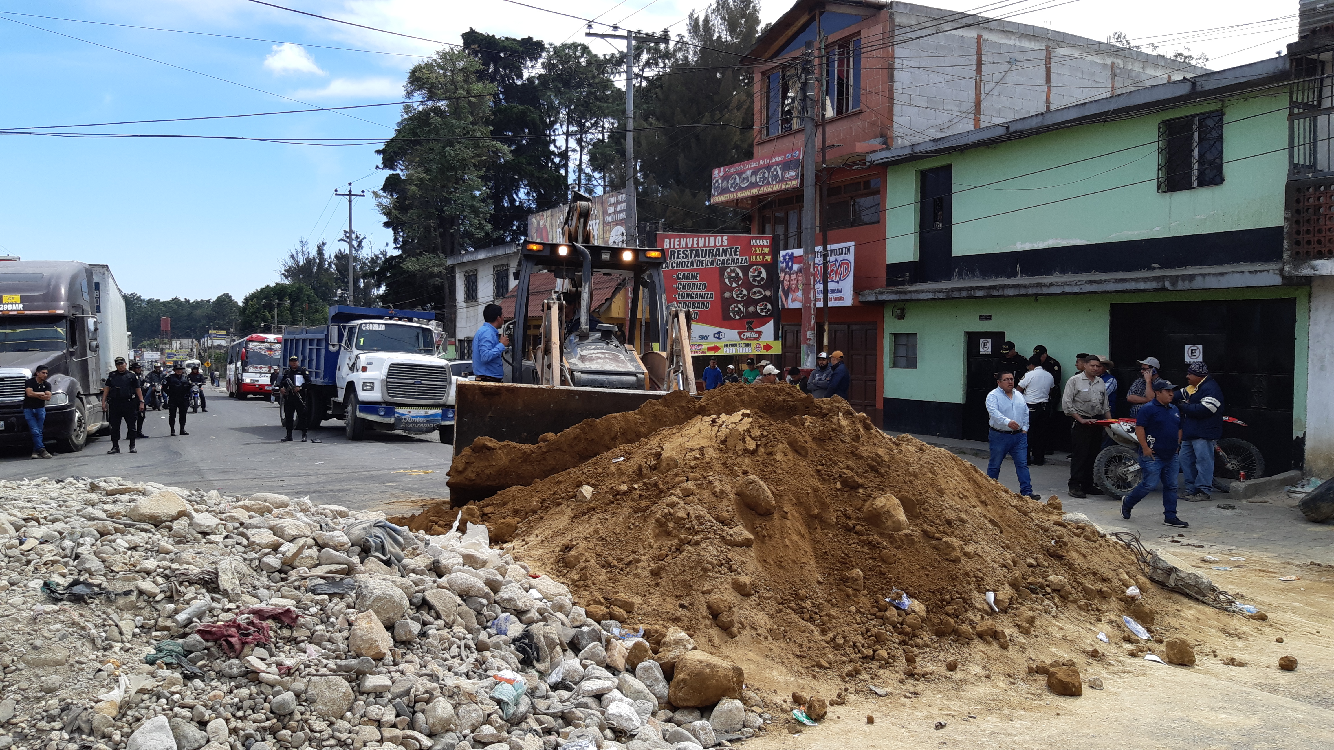 Una máquina retira el material que manifestantes colocaron en el kilómetro 56 de la ruta Interamericana para impedir la circulación de vehículos. (Foto Prensa Libre: Julio Sicán). 