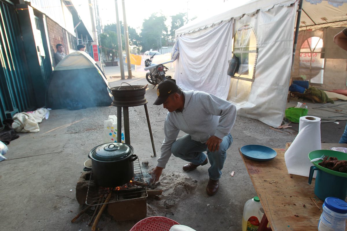 Manifestantes contra la minería utilizan leña para cocinar sus alimentos frente al MEM. (Foto Prensa Libre: Estuardo Paredes)