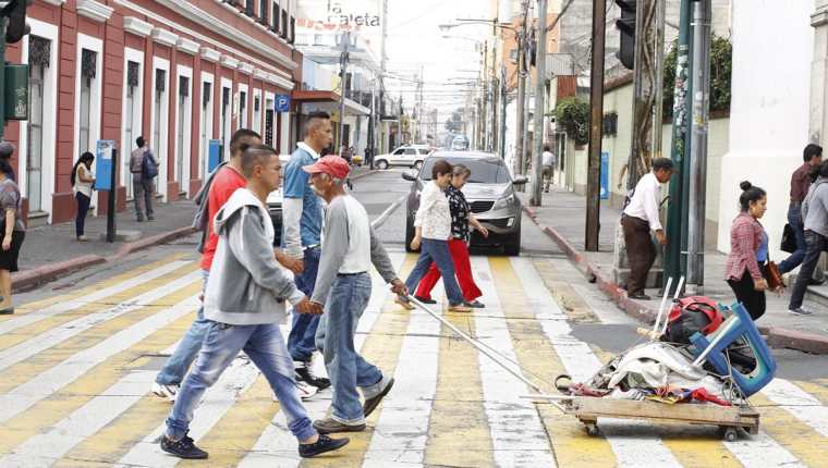 Transeúntes se desplazan por la 7a. avenida y 8a. calle de la zona 1 de la capital. (Foto Prensa Libre: Paulo Raquec).
