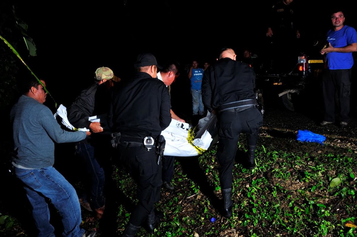 Agentes de la PNC trasladan el cadáver de un maestro que murió por heridas de arma cortante en Sayaxché, Petén. (Foto Prensa Libre: Rigoberto Escobar)