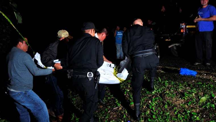 Agentes de la PNC trasladan el cadáver de un maestro que murió por heridas de arma cortante en Sayaxché, Petén. (Foto Prensa Libre: Rigoberto Escobar)