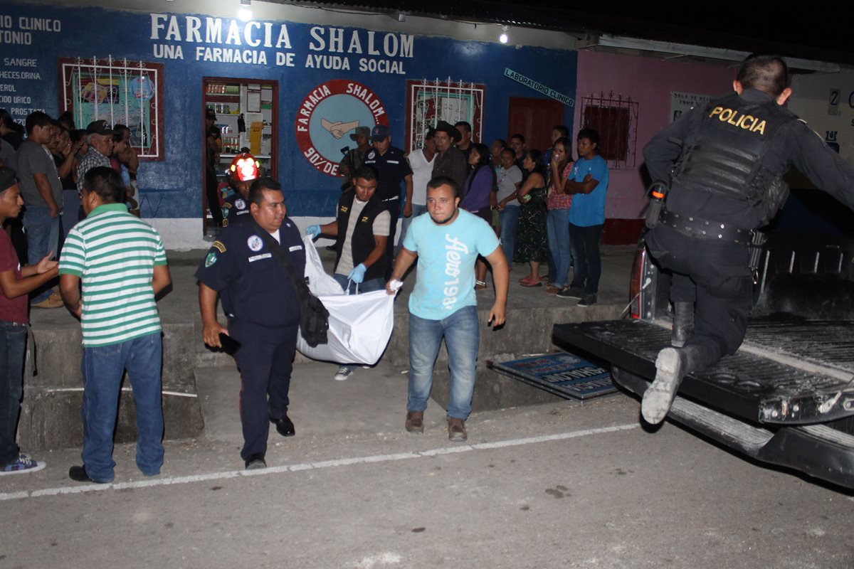 El cuerpo de Jorge Elvidio Gómez Ortiz es llevado por agentes de la PNC hacia la morgue, luego de haber sido ultimado en Dolores, Petén. (Foto Prensa Libre: Walfredo Obando)
