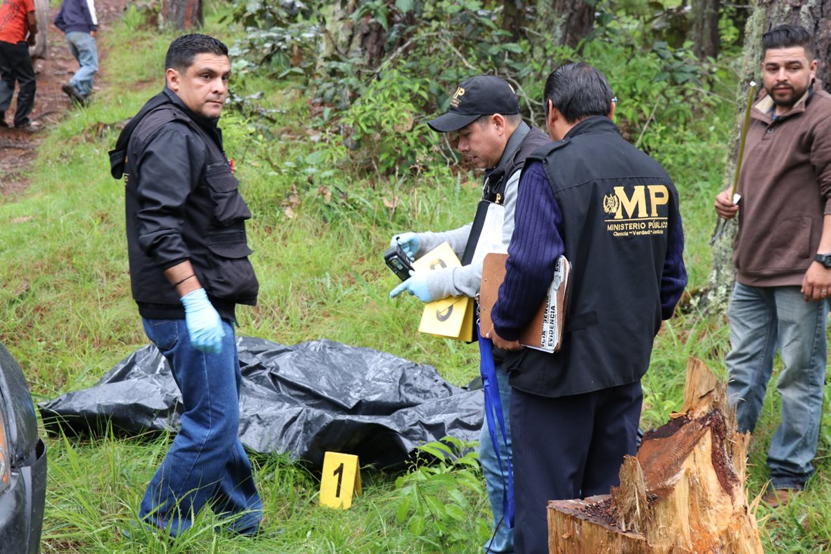 Peritos del MP resguardan el cadáver que fue localizado dentro de un costal en San Pedro Jocopilas, Quiché. (Foto Prensa Libre: Héctor Cordero)