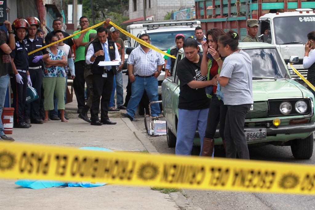 El cuerpo  de Martínez Cantoral yace junto al vehículo en donde viajaba, en compañía de su padre, quien recibió heridas leves  de bala en la cabeza. (Foto Prensa Libre: Estuardo Paredes)
