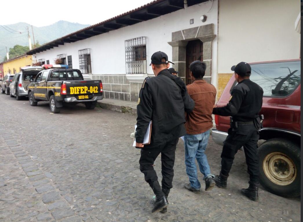 Agentes conducen a uno de los integrantes de la banda "Los Rejoneros", que operaba en Sumpango. (Foto: PNC)