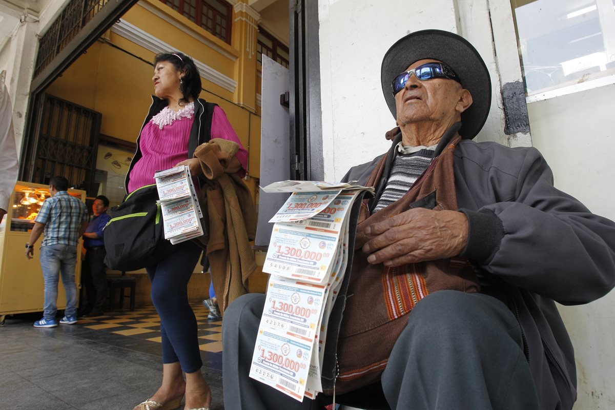 Francisco Gómez, de 90 años, vende números de lotería junto a su hija Marta Lidia Gómez. (Foto Prensa Libre: Paulo Raquec).