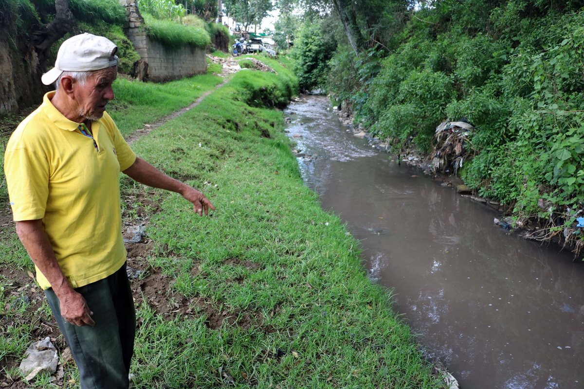 Vecinos muestra el agua contaminada que genera malos olores en Xela. (Foto Prensa Libre: Carlos Ventura).