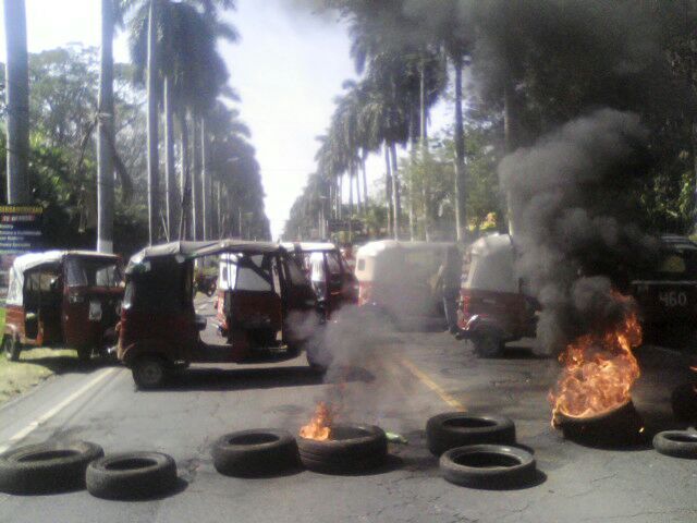 Pilotos de mototaxis queman neumáticos e impiden el paso de vehículos en la cabecera de Retalhuleu. (Foto Prensa Libre: Jorge Tizol)
