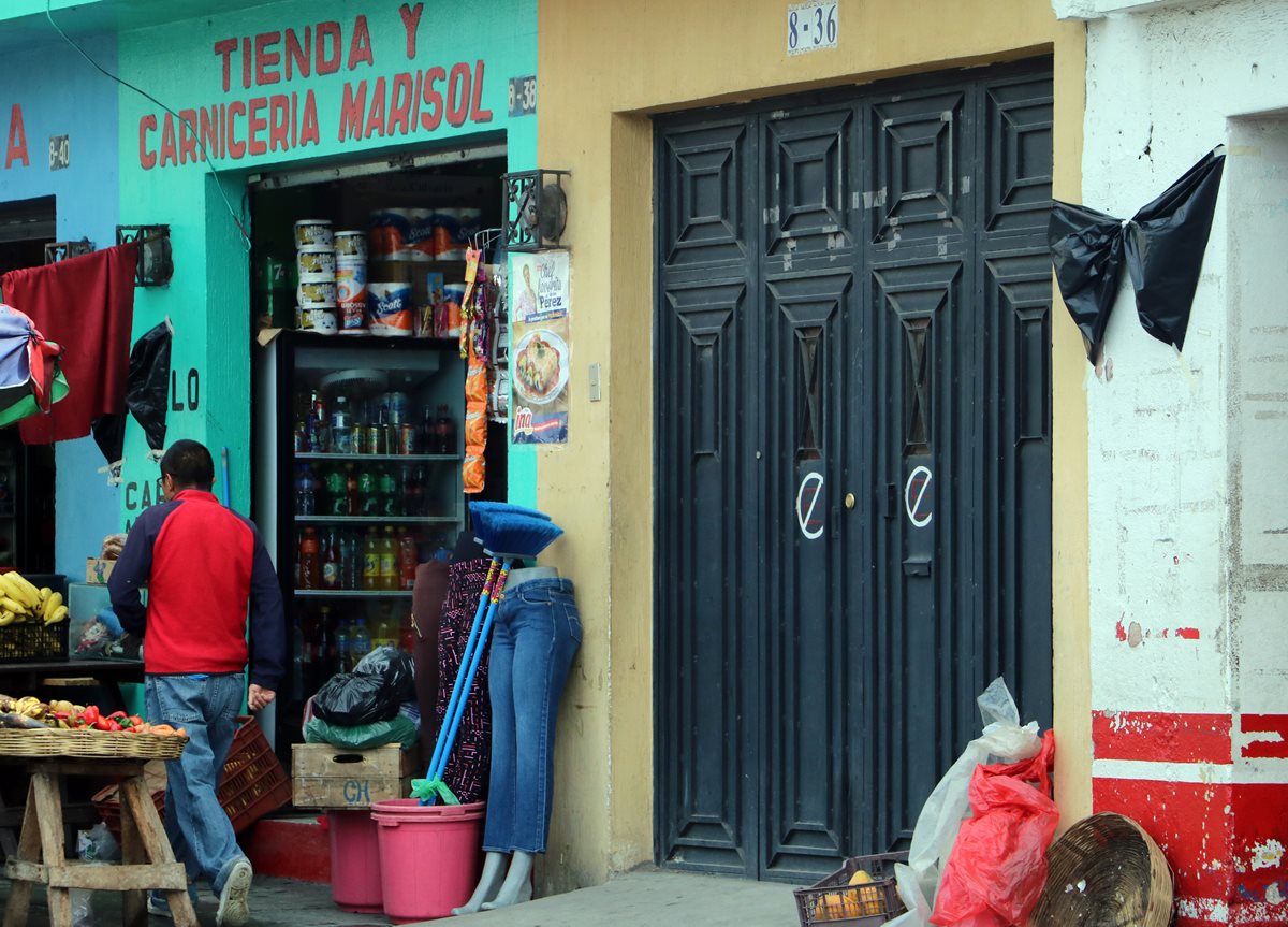 Vecinos y comerciantes de la 3a. calle, zona 2 de Xelajú, colocaron moñas negras en sus negocios como muestra de repudio por el asesinato del comerciante Rolando Cuc, de 37 años. (Foto Prensa Libre: Carlos Ventura)