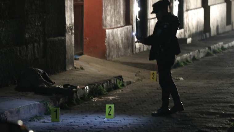 Investigadores del MP recolectaron indicios en la escena crimen, en la zona 1 de Xela, y toman fotografías del lugar y de la víctima. (Foto Prensa Libre: María José Longo)