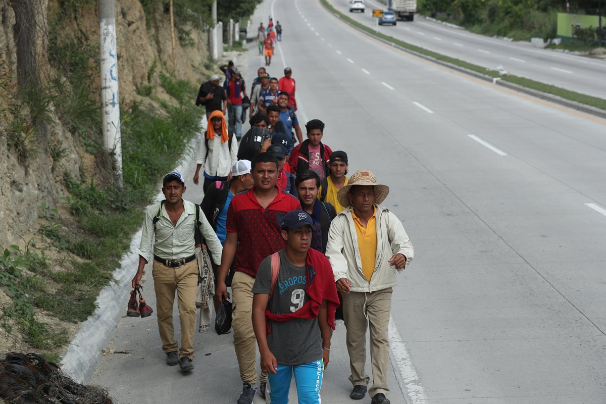 Un grupo de migrantes camina sobre el km 50 de la ruta al Atlántico con la esperanza de encontrar a algún automovilista que les de un "aventón". (Foto Prensa Libre: Esbin García)