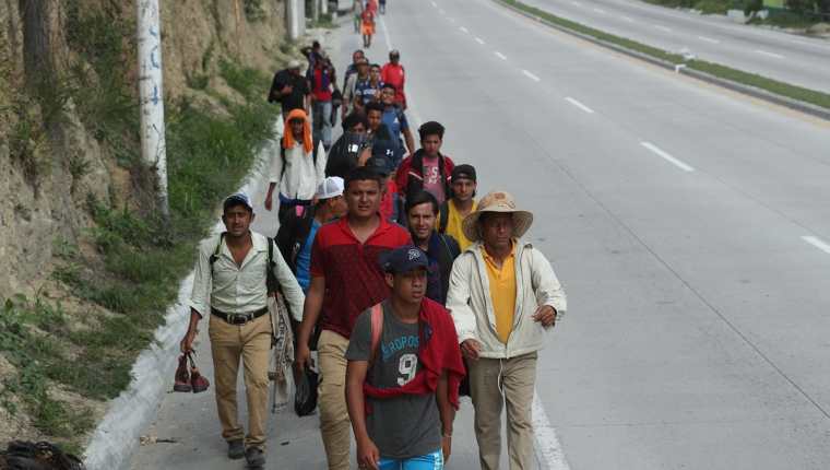 Un grupo de migrantes camina sobre el km 50 de la ruta al Atlántico con la esperanza de encontrar a algún automovilista que les de un "aventón". (Foto Prensa Libre: Esbin García)