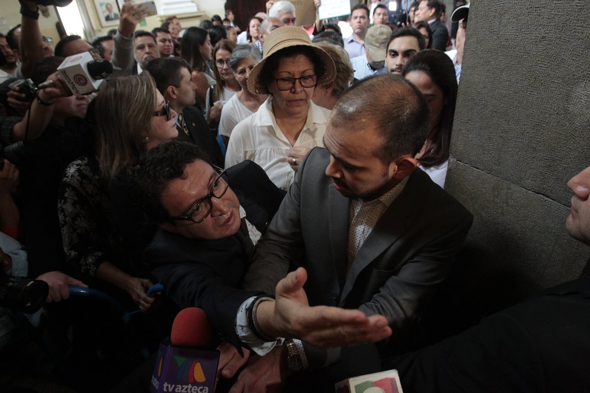 El diputado Álvaro Velásquez, quien se ha manifestado en favor de las reformas, intenta ingresar en uno de los pasillos del Congreso, pero se lo impiden los opositores. (Foto Prensa Libre: C. Hernández )