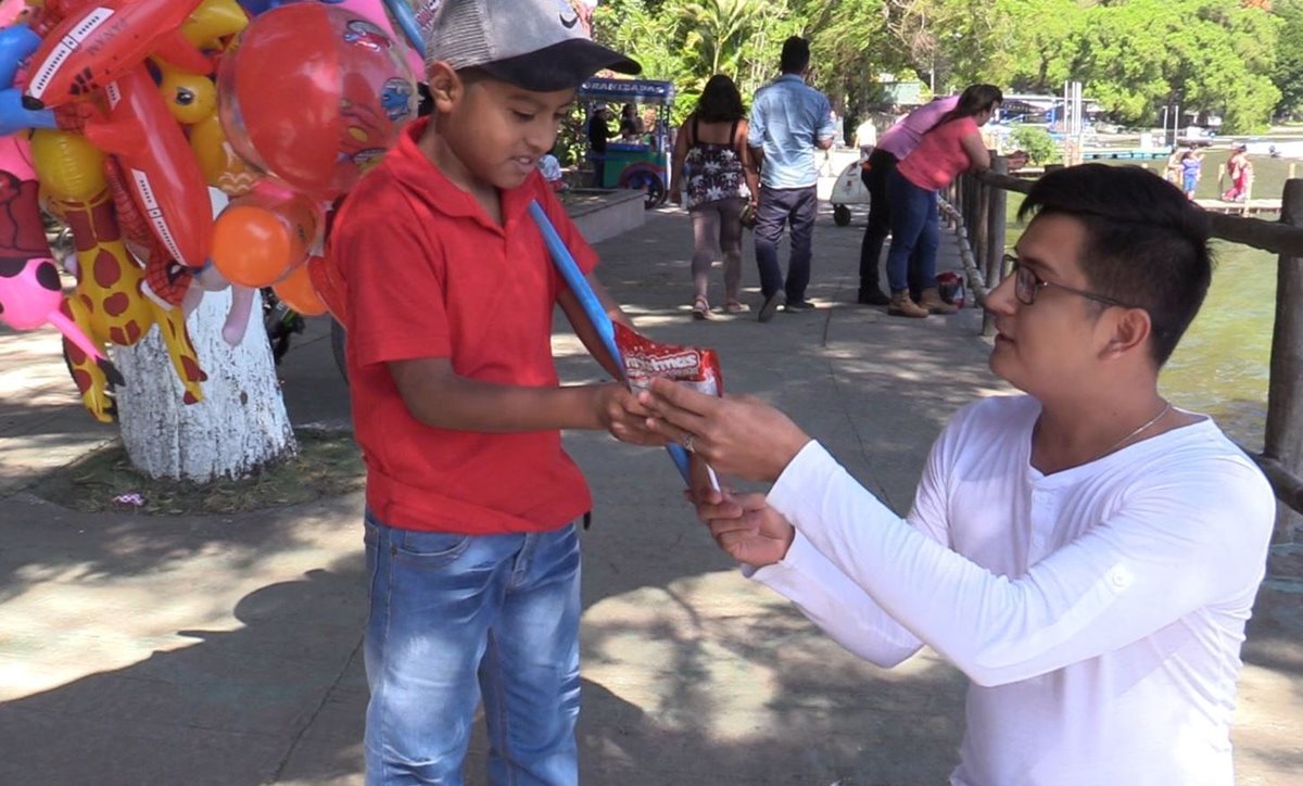 Uno de los niños vendedores del Lago de Amatitlán conversa con Oliver Reyes. (Foto Prensa Libre: Juan Carlos Rivera)