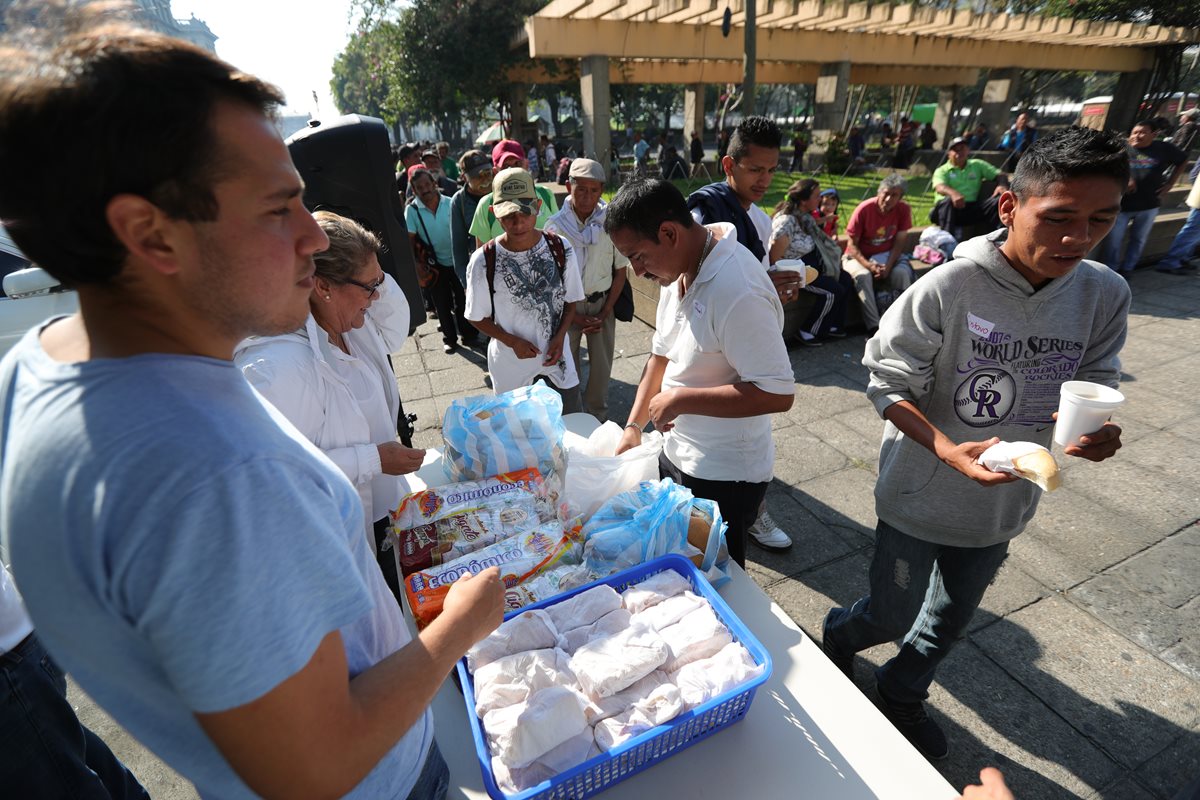 Personas sin hogar reciben sus alimentos en la actividad del Ministerio Dios es Dios, en el parque central de la Ciudad de Guatemala. (Foto Prensa Libre: Carlos Hernández).