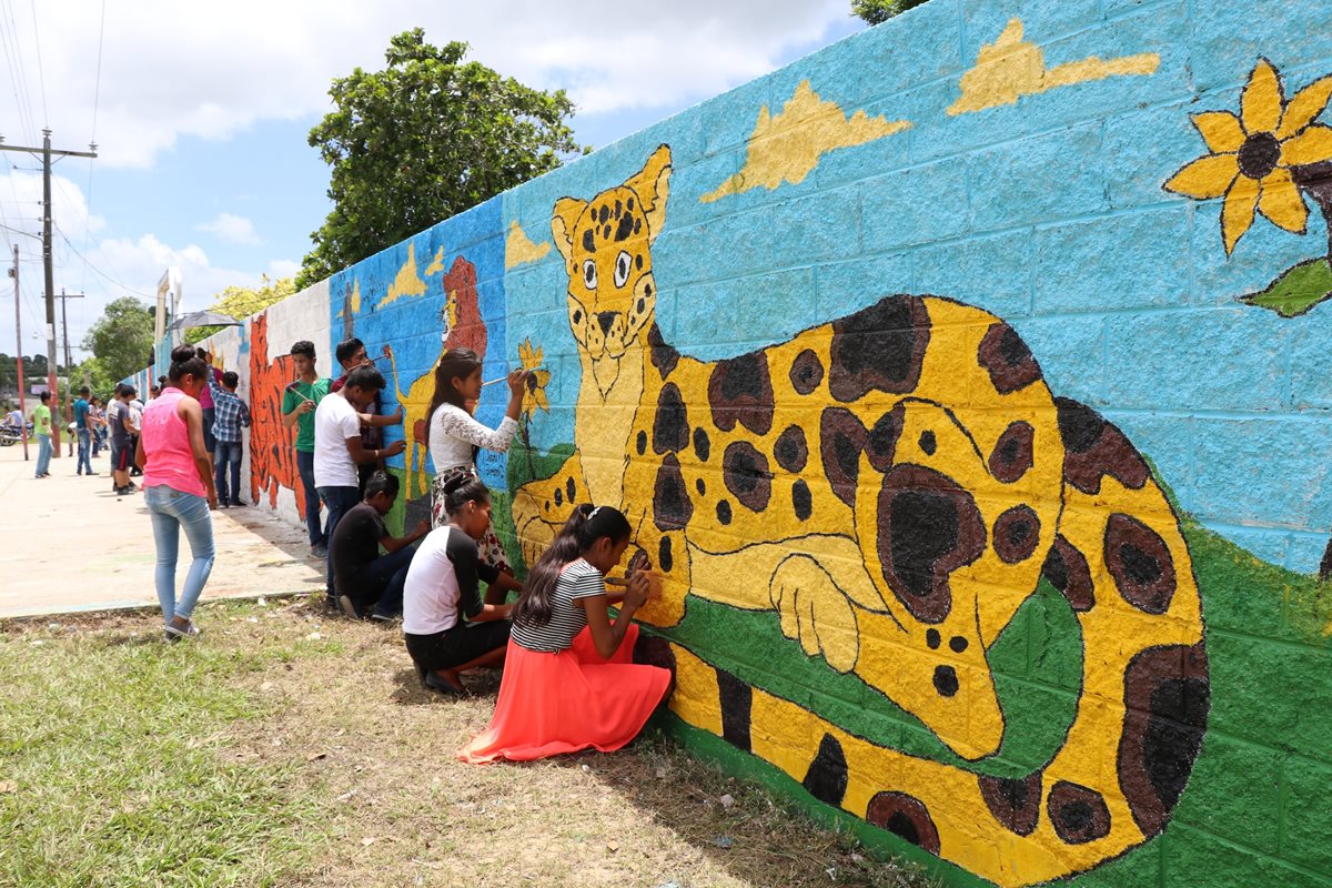 Estudiantes peteneros pintan las paredes de su instituto, camino al parque Tikal. (Foto Prensa Libre: Rigoberto Escobar)