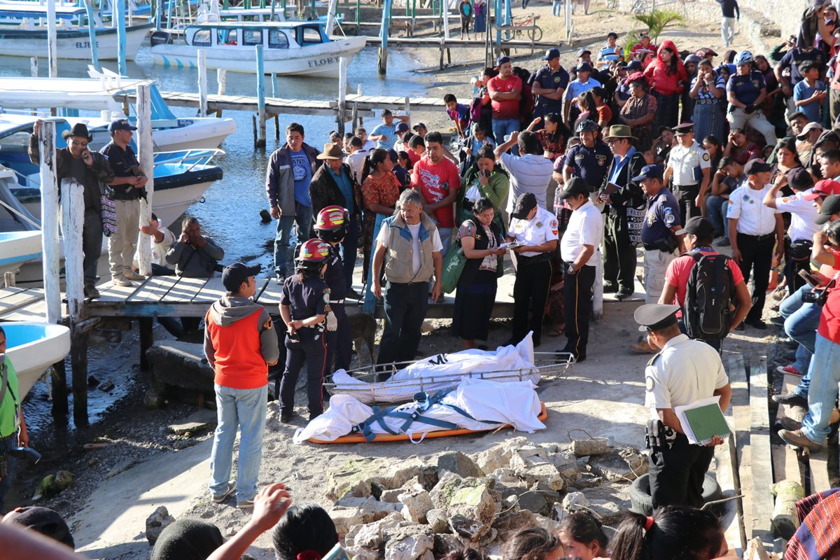 Los cuerpos de las víctimas fueron llevados a la playa pública de Panajachel, donde Fiscales del MP recaban evidencias. (Foto Prensa Libre: Yesica Medrano)
