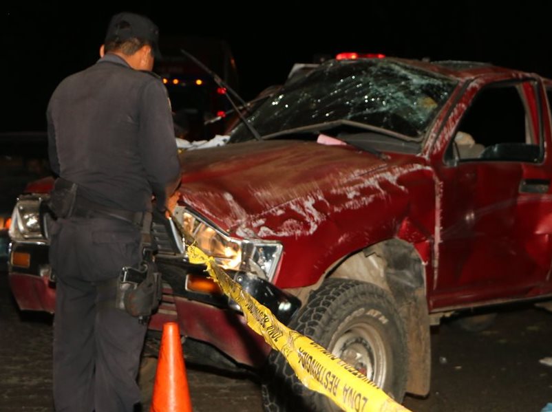 Agente de la PNC observa el picop en el que se conducía la familia afectada. (Foto Prensa Libre: Rolando Miranda)