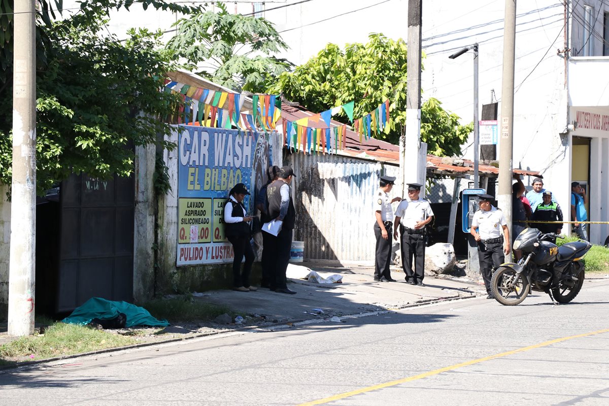 El ataque armado en el que murieron dos agentes de la PNC se registró frente a un car wash en Santa Lucía Cotzumalguapa, Escuintla. (Foto Prensa Libre: Carlos E. Paredes)