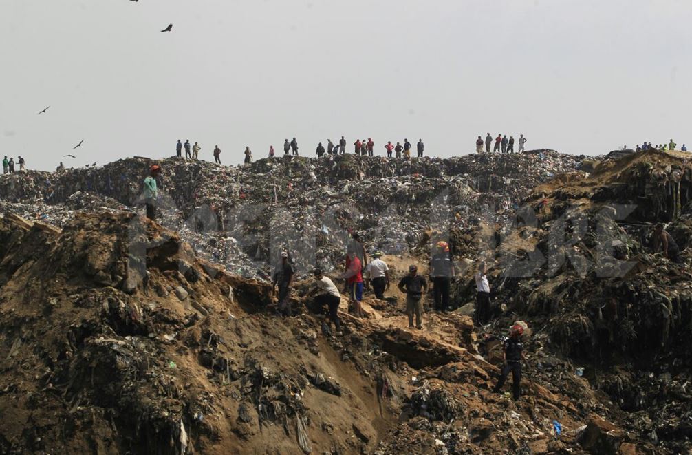 Al menos cuatro camiones recolectores de basura habrían quedado soterrados. (Foto Prensa Libre: Edwin Bercián)