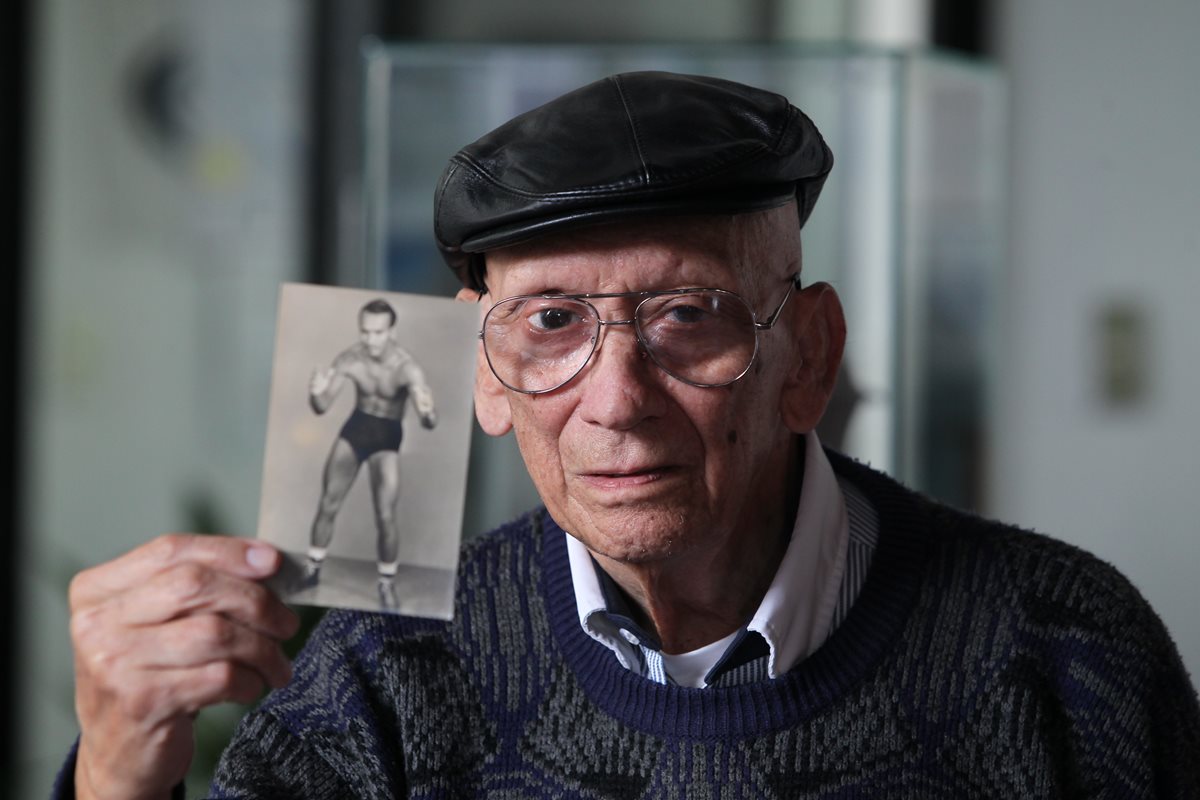 Johnston tiene 87 años; aquí muestra una fotografía que data de la década de 1950, cuando era luchador profesional. Foto Prensa Libre: Érick Ávila.