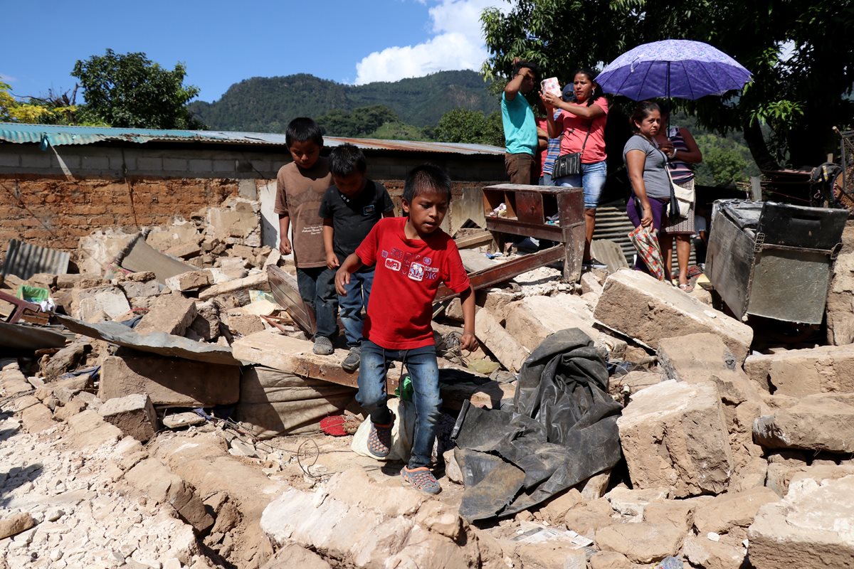 Vecinos observan una de las viviendas destruidas por el terremoto en La Democracia, Huehuetenango. (Foto Prensa Libre: Mike Castillo)