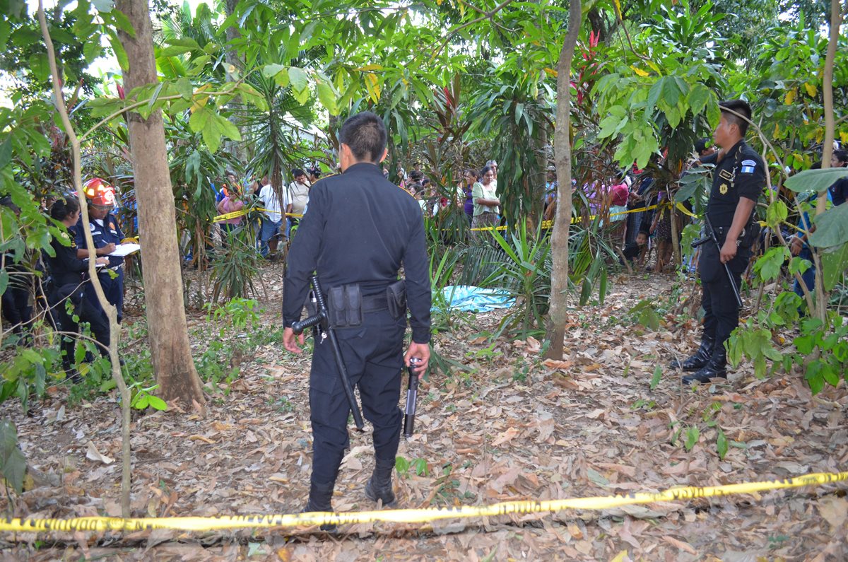 Policías observan el cuerpo del fletero Ambrosio Juárez. (Foto Prensa Libre: Jorge Tizol)