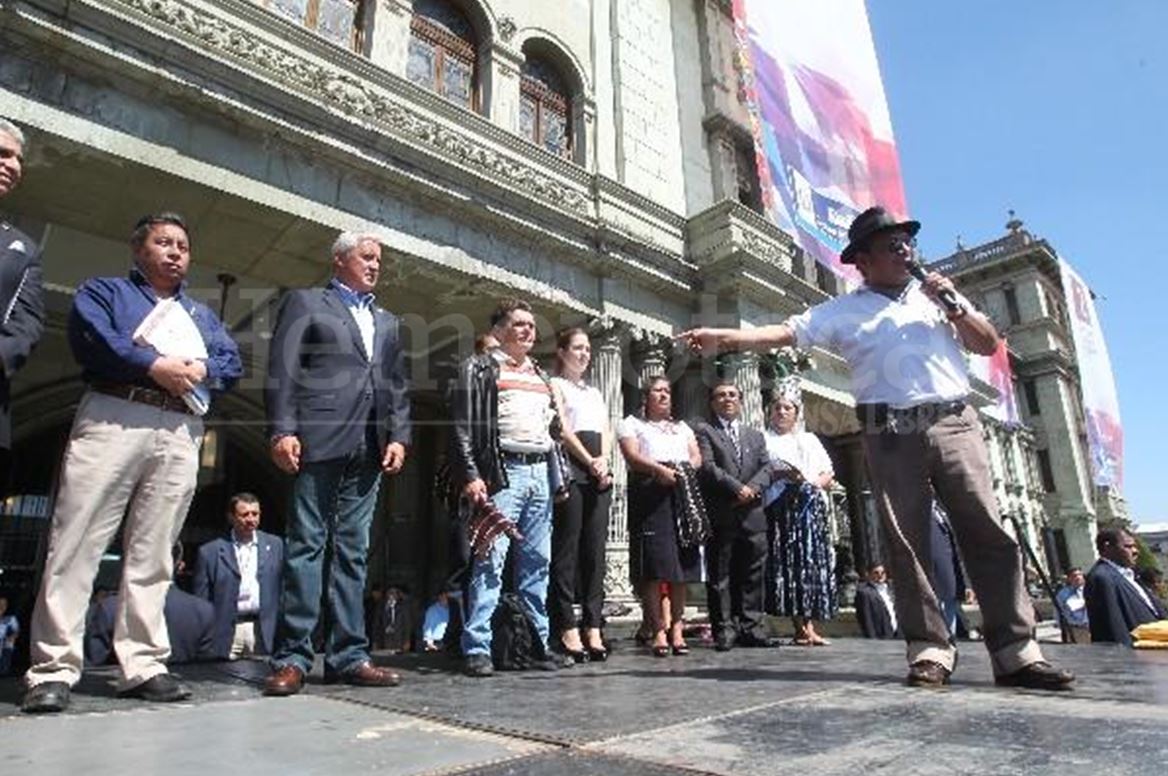 En el 2014, Pedro Esquina -con micrófono- elogia y agradece al presidente Otto Pérez Molina por el pago de la deuda agraria. (Foto Prensa Libre: Hemeroteca PL)