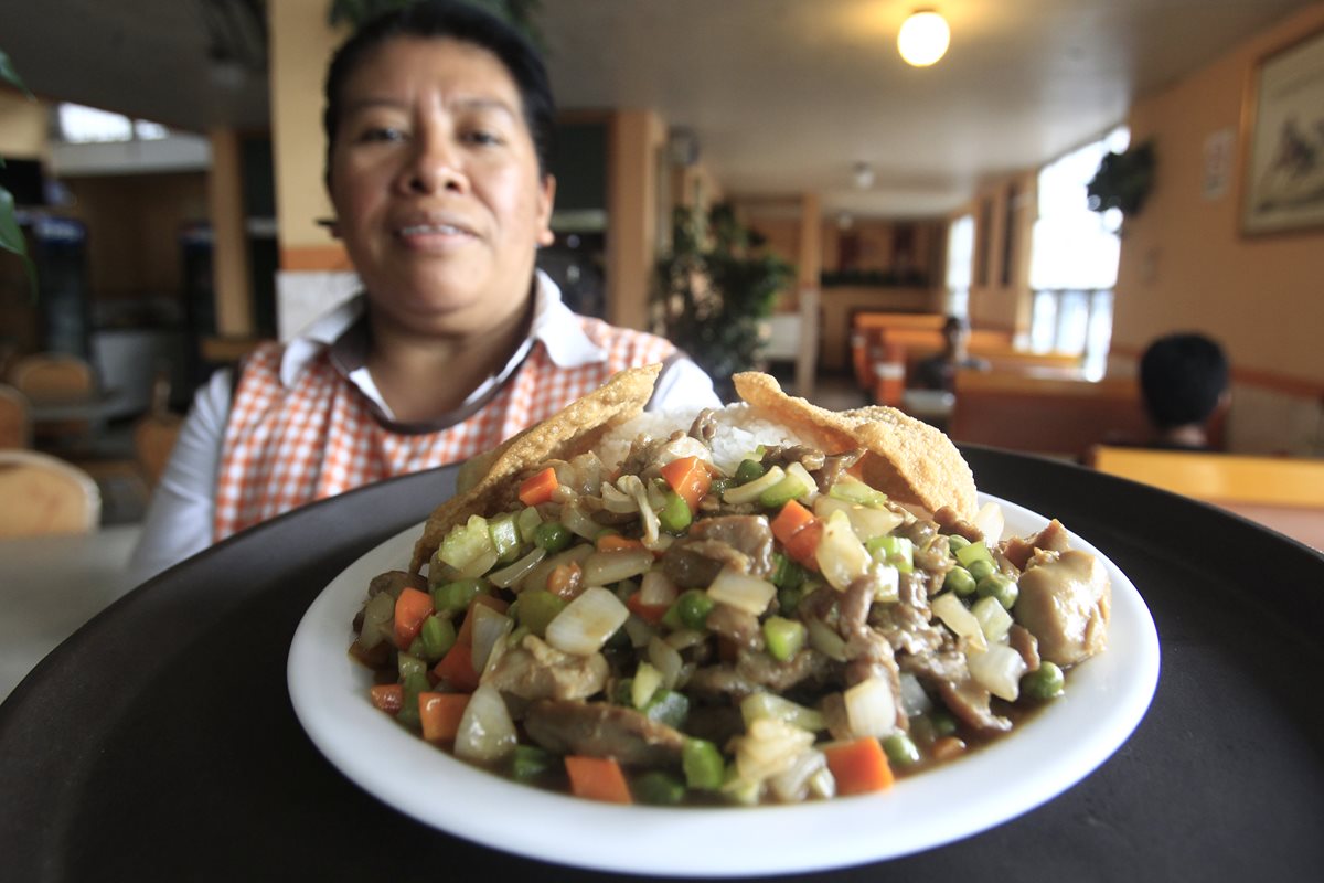 Cristi López muestra uno de los platillos que ofrecen en el restaurante de comida china El Pegaso. (Foto Prensa Libre: Carlos Hernández).