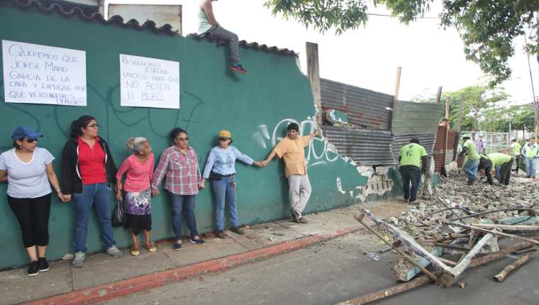 Vecinos de la colonia Eureka se oponen a que la municipalidad derribe el muro perimetral. (Foto Prensa Libre: Érick Ávila)