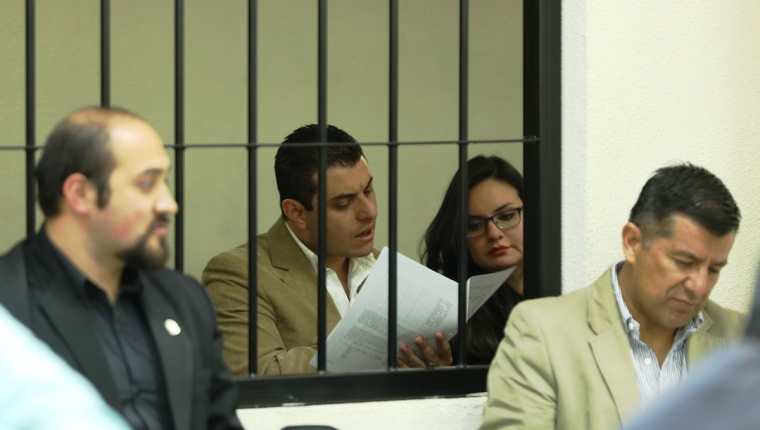 René Arturo Morales y su esposa Carmen Barrientos Salguero, yerno e hija del exalcalde de Xela, leen la acusación que les hace la Fiscalía Especial contra la Impunidad. (Foto Prensa Libre: Mynor Toc) 