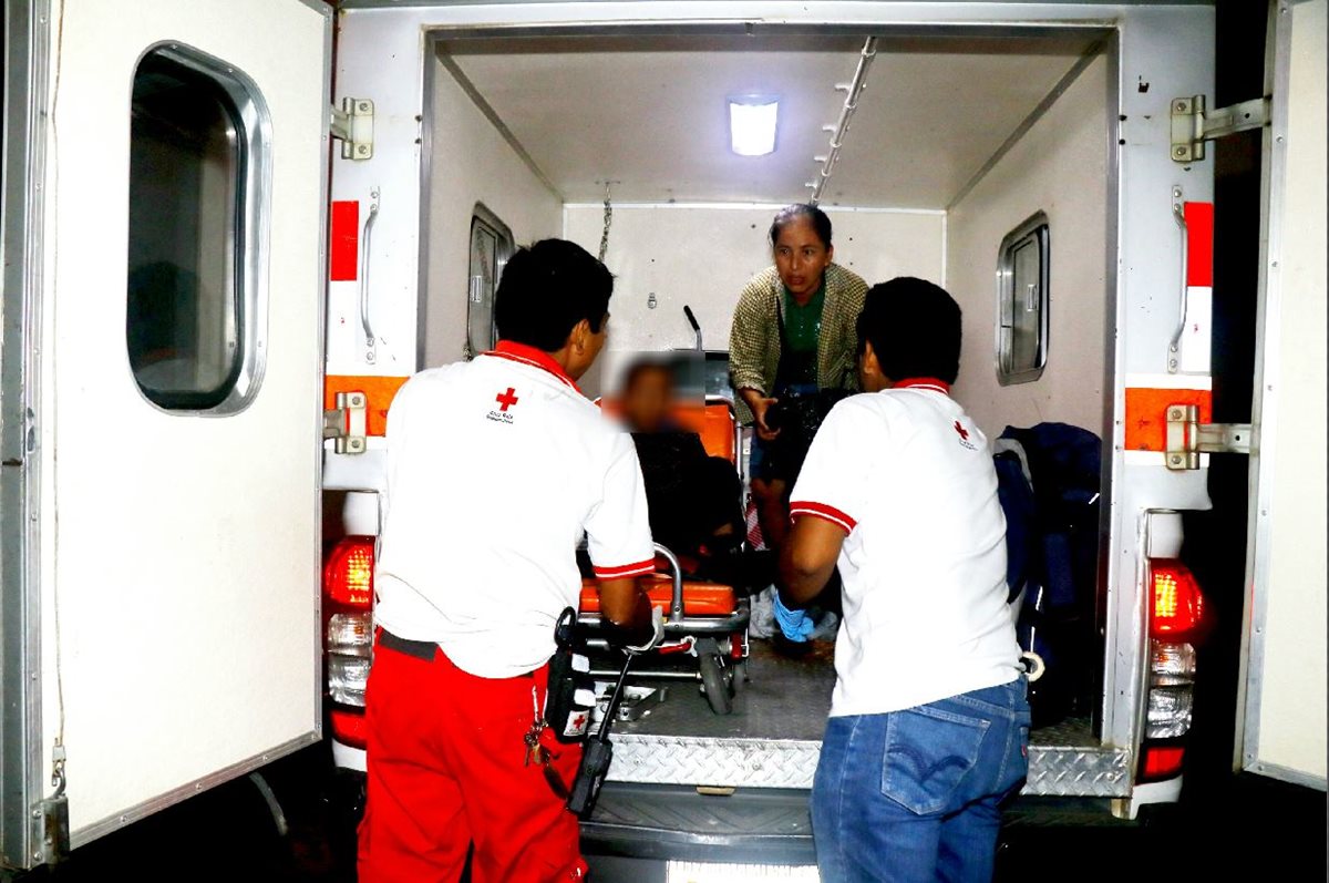 Reina Ester Jerez, esposa del pastor fallecido, acompaña en una ambulancia de la Cruz Roja a su hijo de 8 años, quien resultó herido. (Foto Prensa Libre: Rolando Miranda)