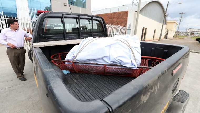 Momento en que el autopatrulla de la PNC llega a las instalaciones del Inacif en Xela con el cadáver y el recipiente de plástico. ( Foto Prensa Libre: Mynor Toc)