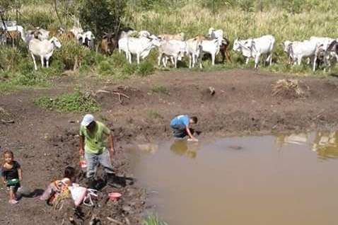 Familia se abastece de agua en un estanque artificial en San Andrés, Petén. (Foto Prensa Libre: Rigoberto Escobar)