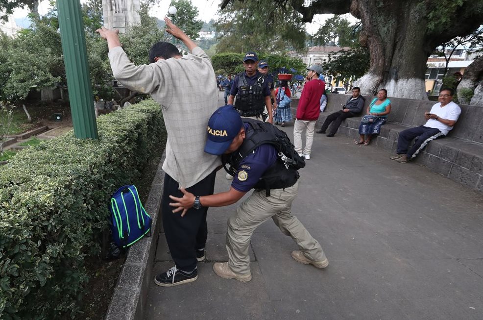 Un agente de la Disetur revisa a un hombre ebrio que escandalizaba dentro del parque central de Xela. (Foto Prensa Libre: Mynor Toc) 