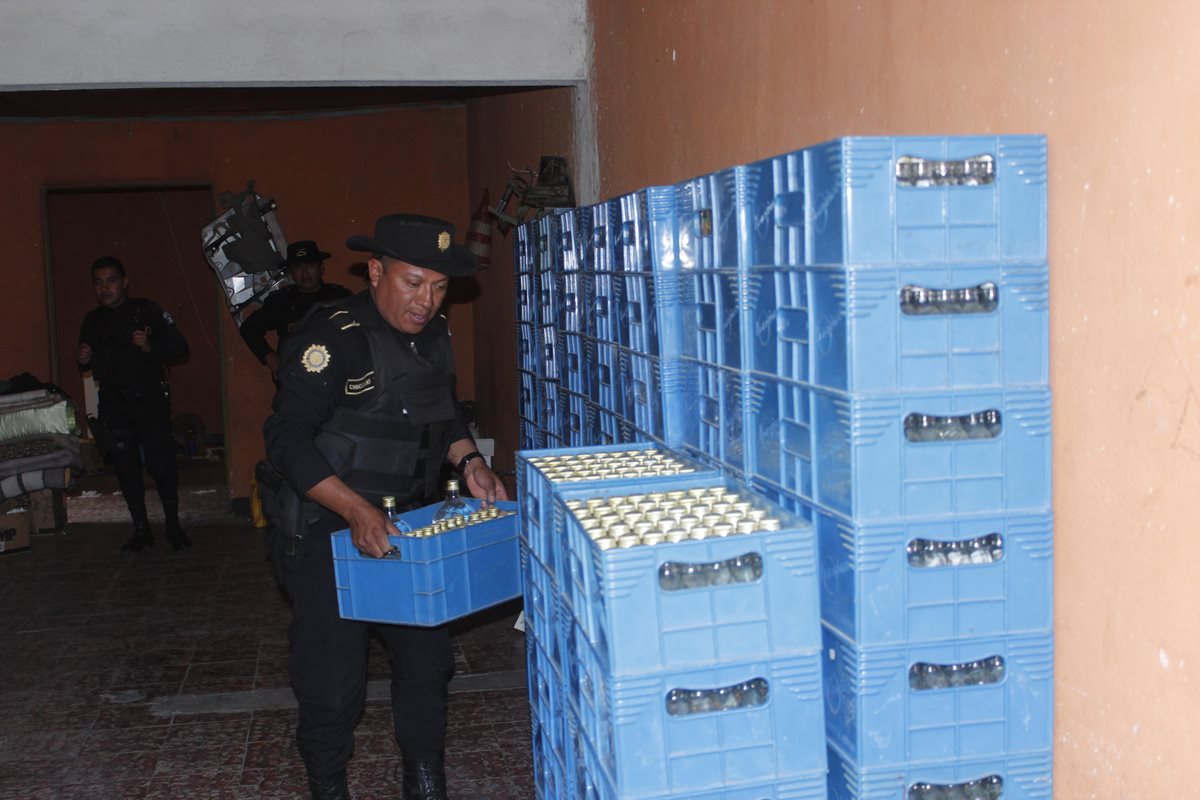 Un agente de la PNC contabiliza cajas de licor decomisadas en la cabecera de Chimaltenango. (Foto Prensa Libre: Víctor Chamalé)