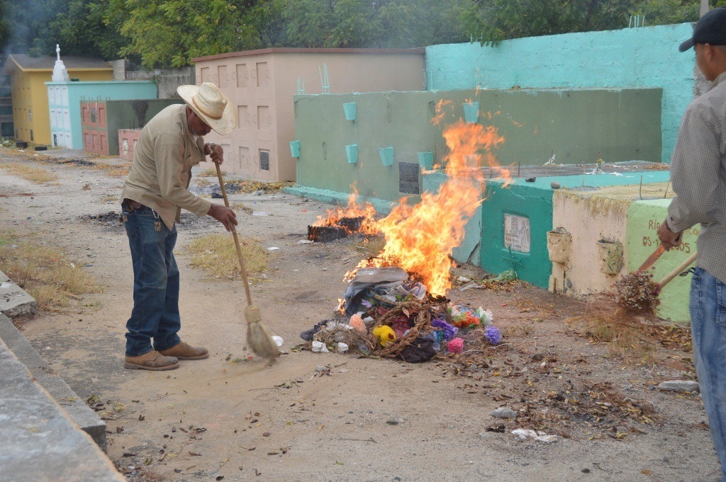 Dos empleados municipales queman basura en el cementerio de Zacapa. (Foto Prensa Libre: Víctor Gómez).