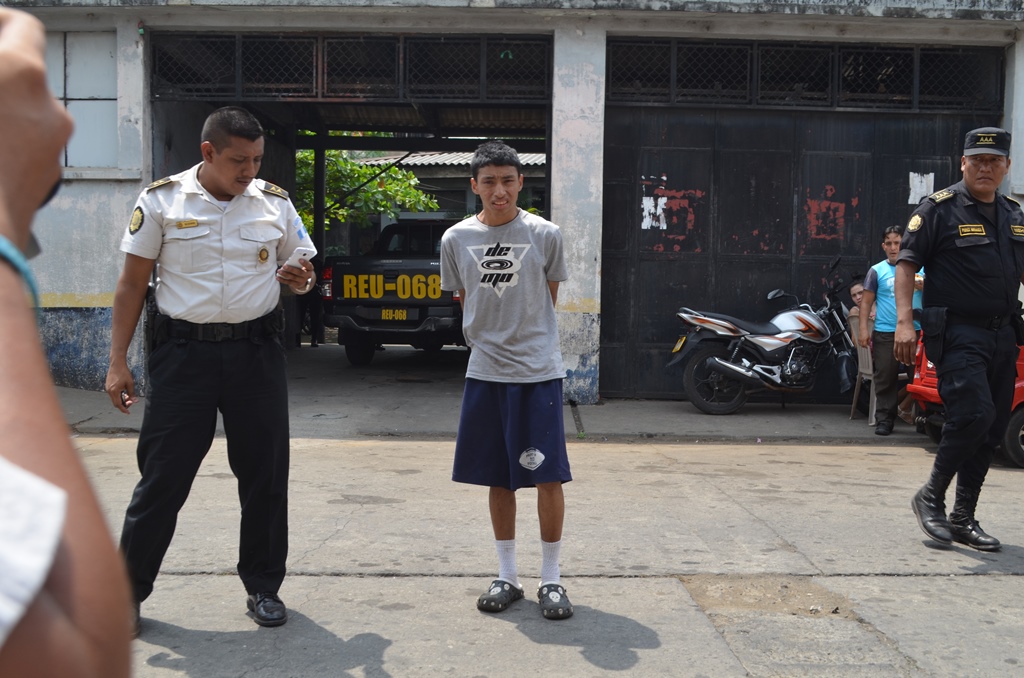 Agente custodia a capturado con arma de fuego ilegal, en la cabecera de Retalhuleu. (Foto Prensa Libre: Jorge Tizol)