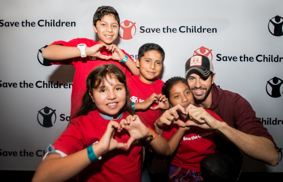 El intérprete Enrique Iglesias compartió con algunos niños que apoya la organización Save the Children para erradicar el analfabetismo en El Quiché.(Foto Prensa Libre: Cortesía Save the Children)