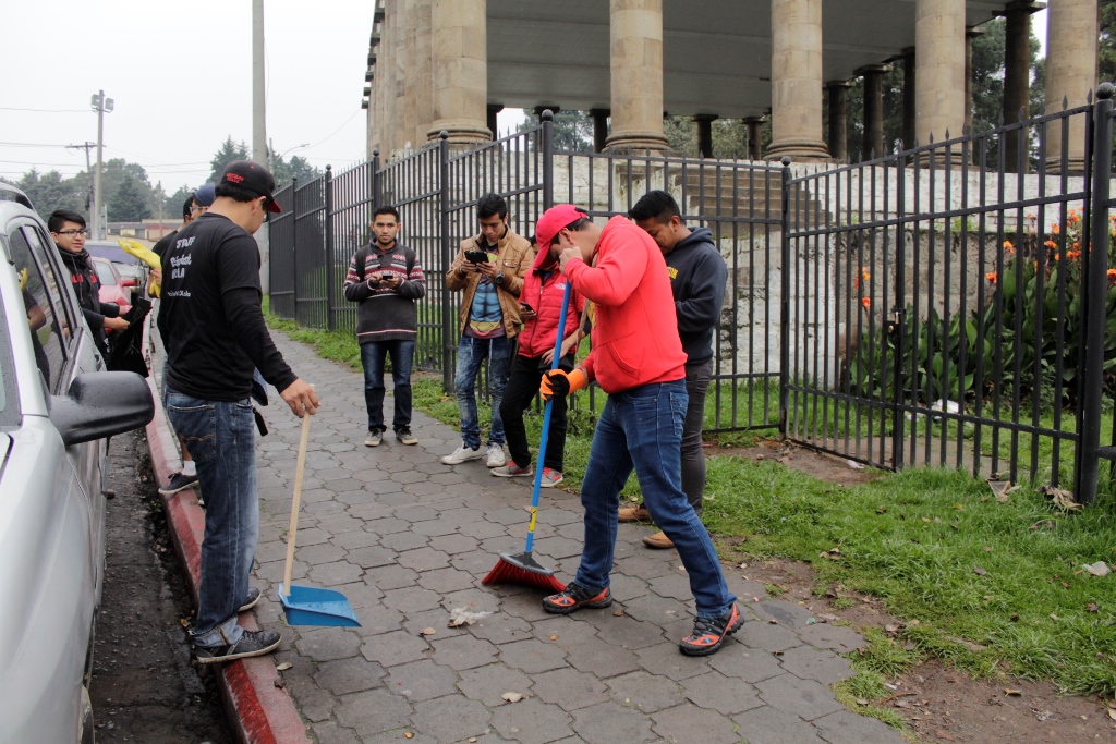 Jóvenes combinan la actividad ambiental con el juego en sus teléfonos celulares. (Foto Prensa Libre: María José Longo).