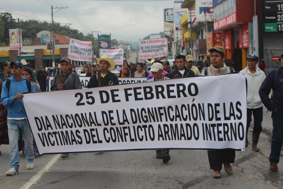 Familiares de la víctimas marcharon por las calles de Cobán con pancartas. (Foto Prensa Libre: Ángel Martín Tax)
