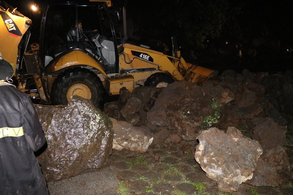 Maquinaria mueve la pesada roca que cayó sobre la ruta a Retalhuleu. (Foto Prensa Libre: María José Longo)