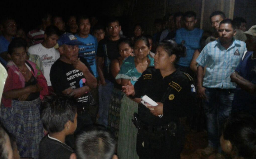 Agente de la PNC dialoga con pobladores, quienes se opusieron al traslado del cadáver de recién nacido en Panzós. (Foto Prensa Libre: Eduardo Sam).
