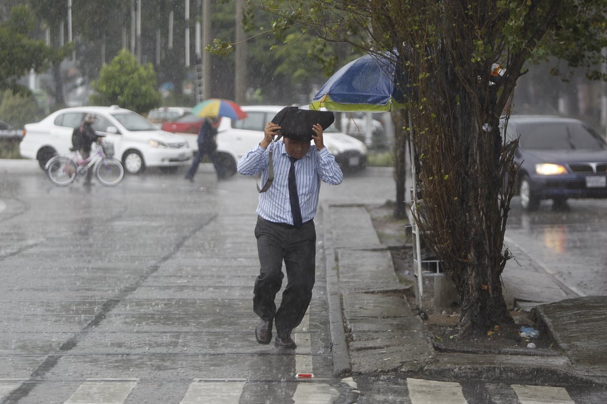 Un hombre se protege de la lluvia en una sector de la ciudad capital. Se espera que las precipitaciones aumenten en la tarde y noche. (Foto Prensa Libre: Hemeroteca PL)