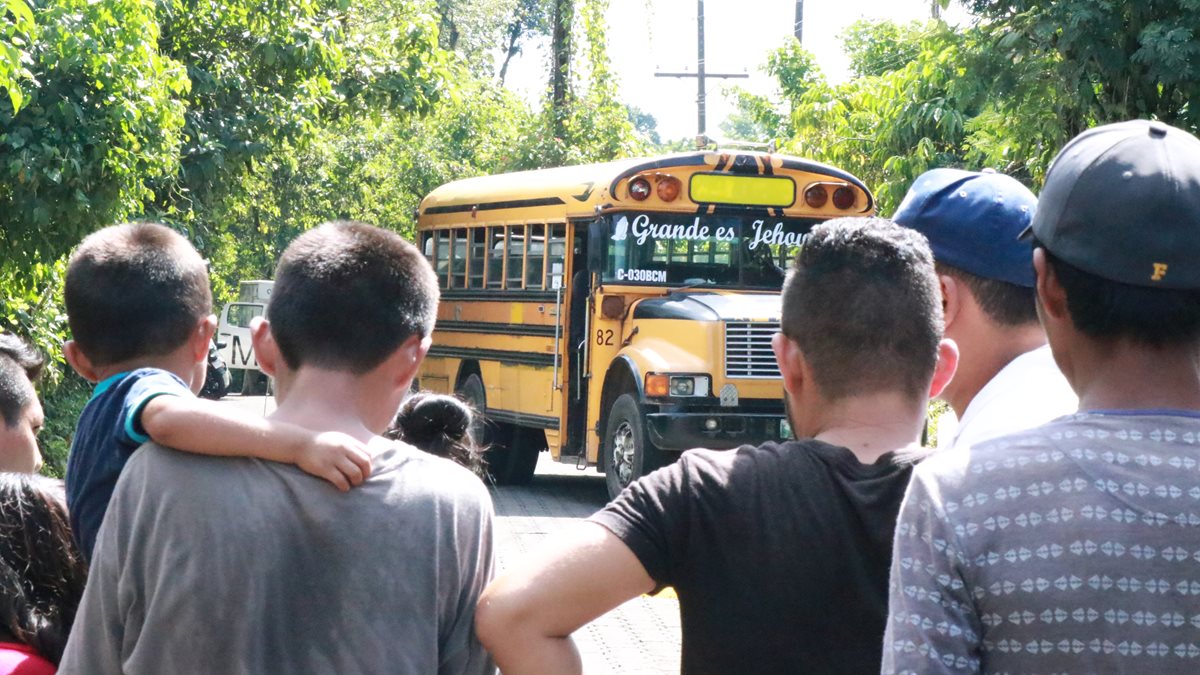 Vecinos observan el bus donde quedó el cadáver del piloto. (Foto Prensa Libre: Cristian Soto)