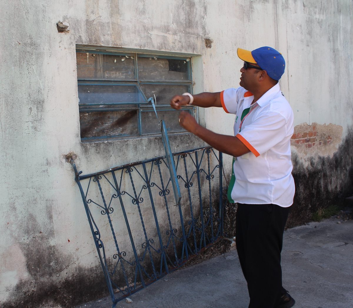 Maestro señala la ventana donde los delincuentes ingresaron a la dirección, hurtaron instrumentos y otros objetos. (Foto Prensa Libre: Óscar González)